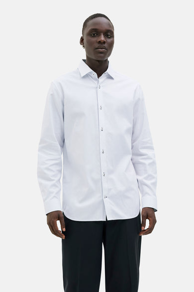 Chemise blanche à manches longues de PREMIUM by JACK & JONES, avec un motif à carreaux subtil, portée avec un pantalon noir.