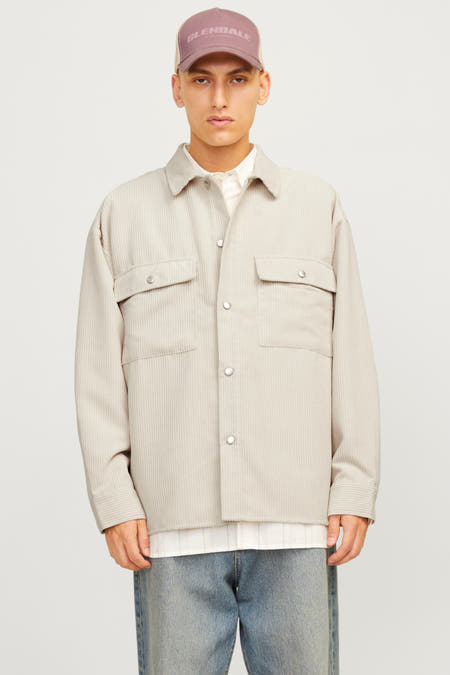 Ecru hemd met lange mouwen van ORIGINALS BY JACK & JONES, gedragen over een wit overhemd en met blauwe jeans.