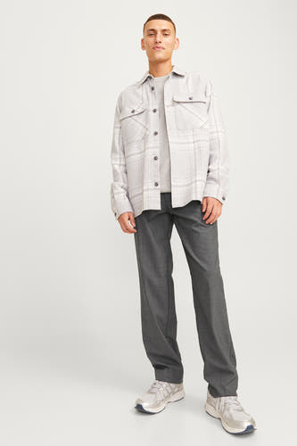 Kostuumbroek in grijs van JACK & JONES JEANS INTELLIGENCE, met lange rechte pijpen, gecombineerd met een grijs shirt en shirtjas met ruitpatroon.