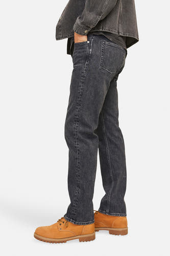 Jean tapered noir de JACK & JONES JEANS INTELLIGENCE, associé à des baskets brunes et une veste en denim.
