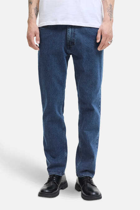 Donkerblauwe straight jeans van JACK & JONES JEANS INTELLIGENCE, gecombineerd met zwarte schoenen en een wit T-shirt.