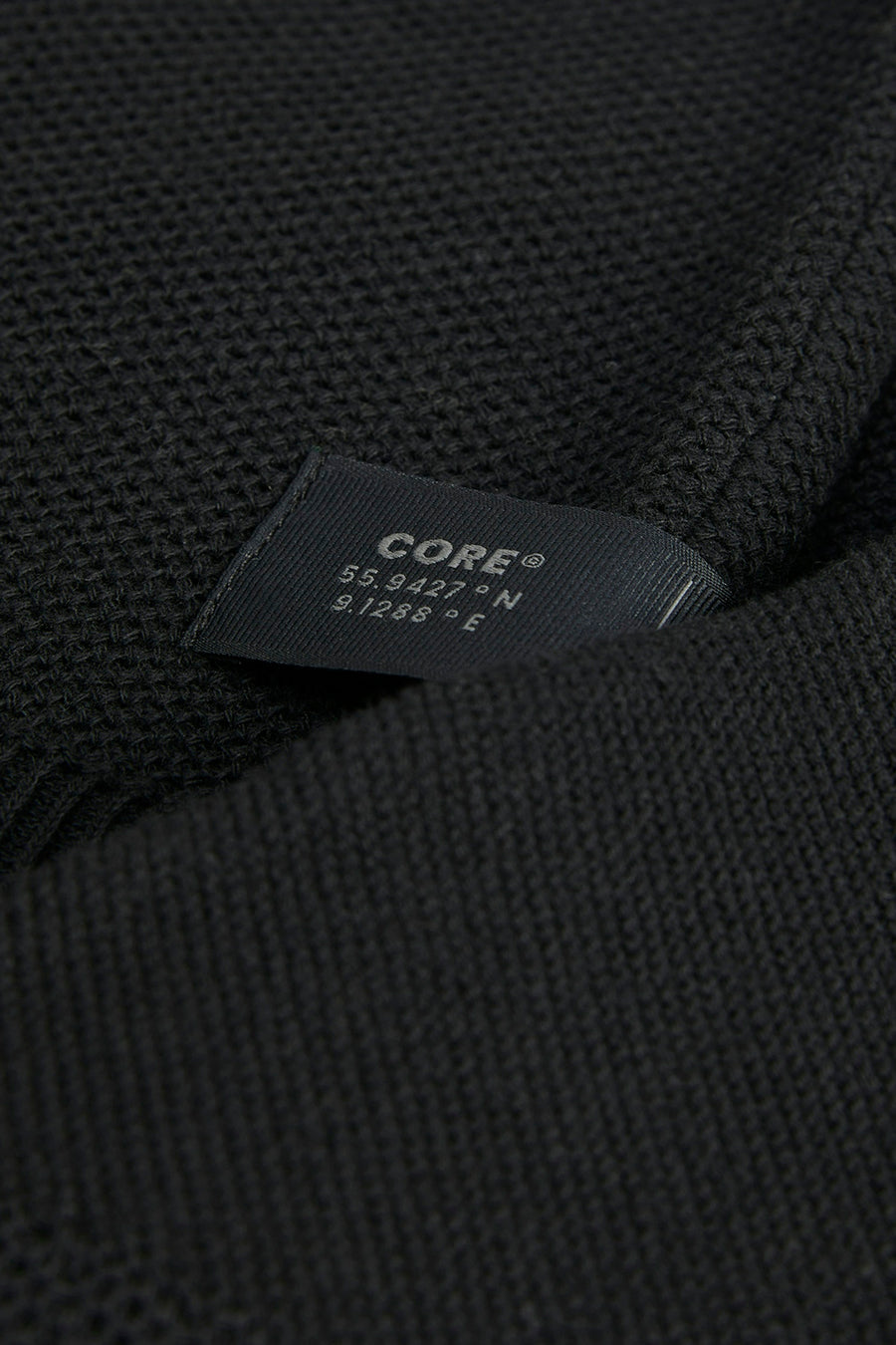 Gilet noir de CORE BY JACK & JONES, avec texture tissée et détail d'étiquette.