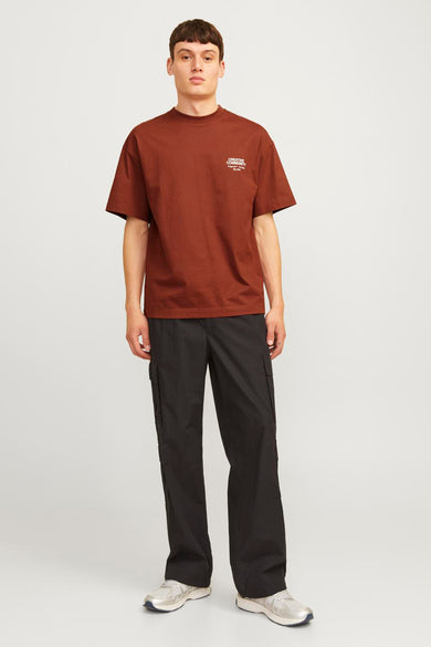 T-shirt rouge à manches courtes d'ORIGINALS BY JACK & JONES, porté avec un pantalon noir et des baskets argentées.
