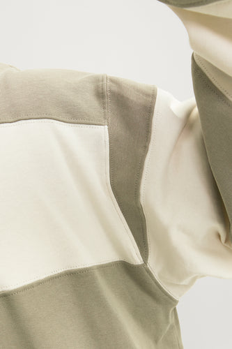 Close-up sweatshirt met groene en crèmekleurige blokken.
