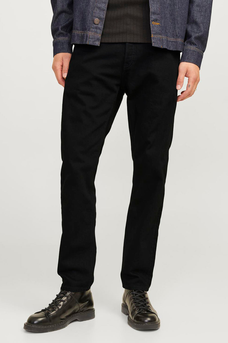 Jeans en denim noir fuselés de Jack & Jones Jeans Intelligence, vus de dos, avec une veste en jean bleu foncé.