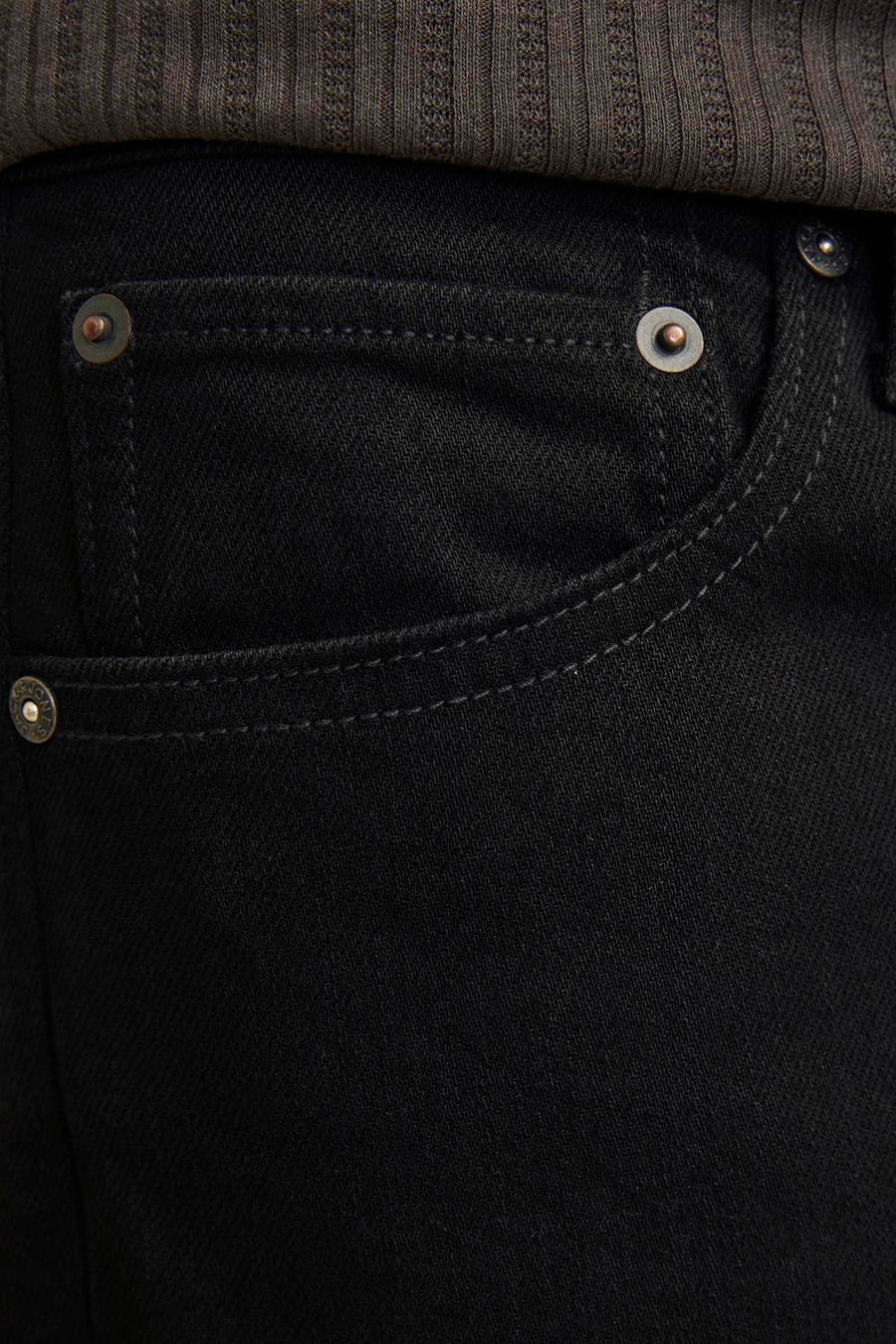 Zwarte tapered jeans van JACK & JONES JEANS INTELLIGENCE, met zakdetail en subtiele stiksels, gecombineerd met een ribgebreide top.
