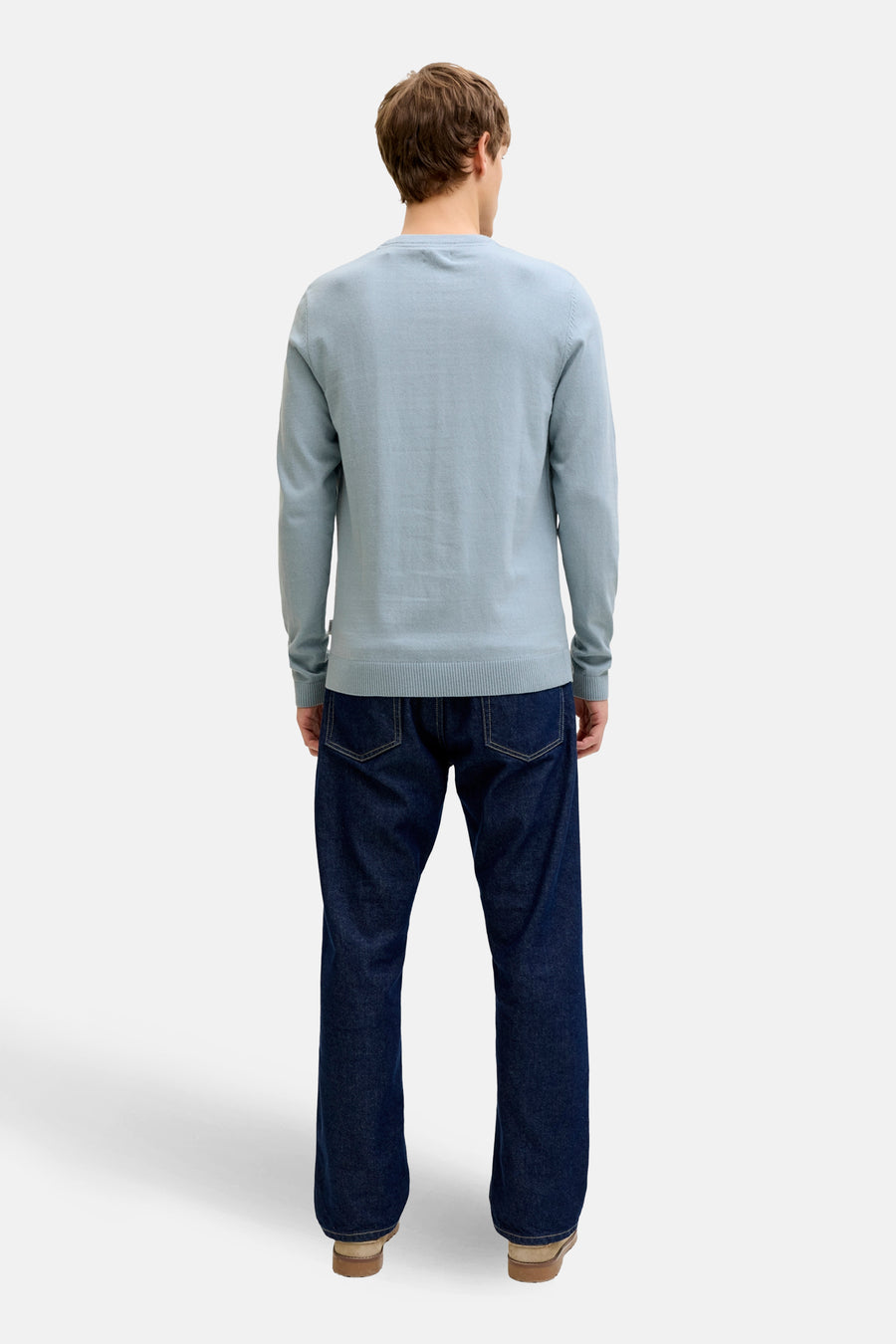 Pull bleu à col rond de JJREBEL, vu de dos, combiné avec un jean foncé et des chaussures marron.