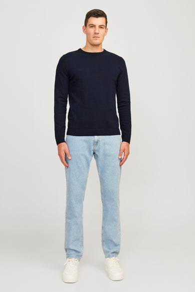 Blauwe trui met ronde hals van JJREBEL, gedragen met lichte jeans en witte sneakers.