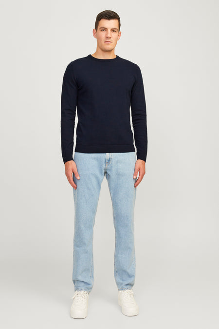 Blauwe trui met ronde hals van JJREBEL, gedragen met lichte jeans en witte sneakers.