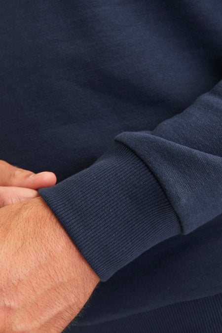 Blauwe sweater van JJREBEL, detailopname van de geribbelde mouw.
