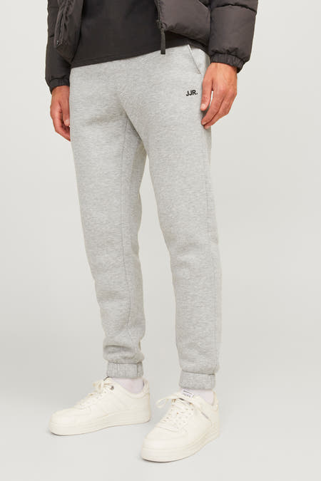 Grijze joggingbroek van JJREBEL, met een aansluitende pasvorm en witte sneakers.