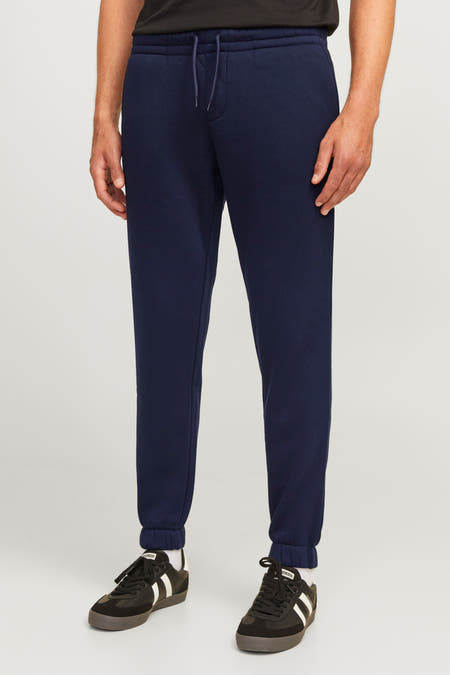 Blauwe joggingbroek van JJREBEL, met trekkoord en zwarte sportschoenen.
