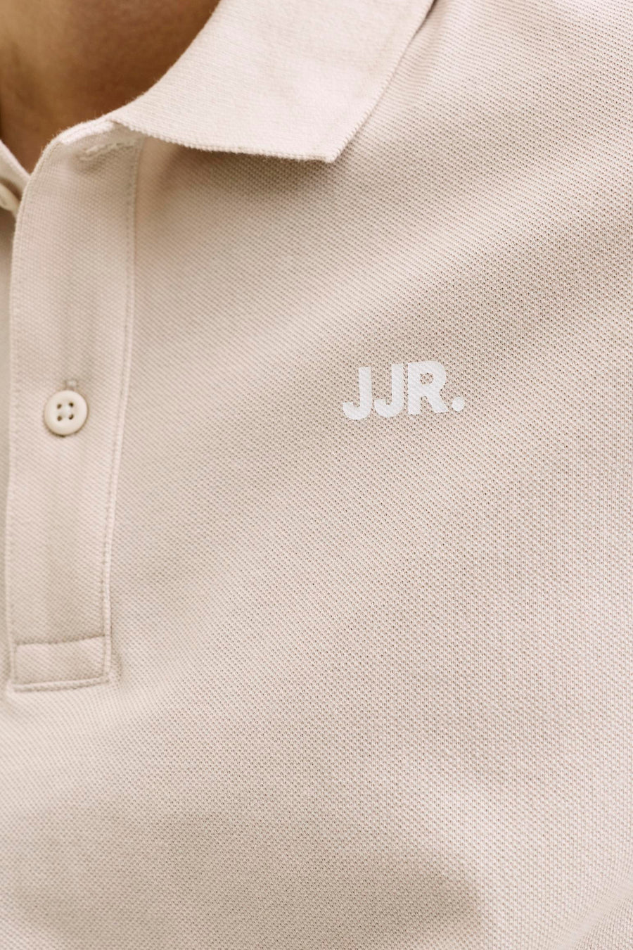 Beige polo van JJREBEL, met korte mouwen en een fijn geweven textuur.
