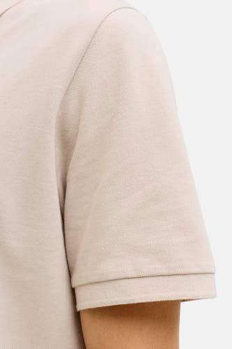 Beige polo van JJREBEL, close-up van de mouw met geribbelde boord en subtiele textuur.
