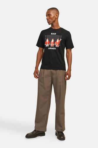 Zwart T-shirt met korte mouwen van ORIGINALS BY JACK & JONES, met 'Bad Santa' kerstprint voor, gecombineerd met een pantalon en leren schoenen.