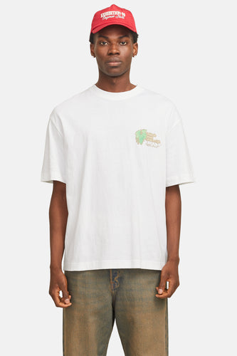 Wit T-shirt met korte mouwen van ORIGINALS BY JACK & JONES, met een logo op de borst en gedragen met een rode pet en jeans.
