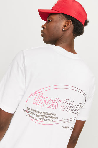 Wit T-shirt met korte mouwen van CORE BY JACK & JONES, met "Track Club"-opdruk op de rug en een rode pet.
