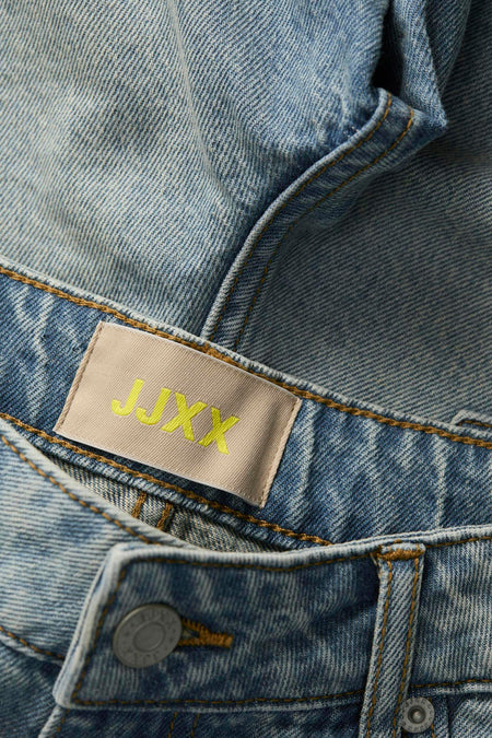 Shorts en denim bleu clair court de JJXX, avec une étiquette de marque beige et des boutons dorés.