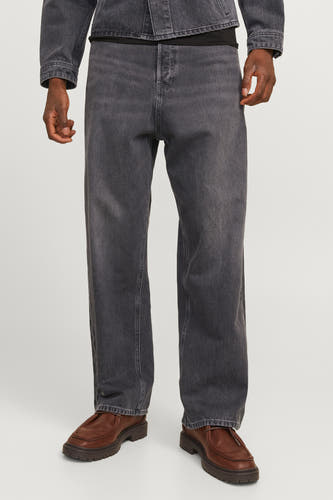 Jean sombre et large de denim par JACK & JONES JEANS INTELLIGENCE, associé à une veste en cuir et des chaussures marron.