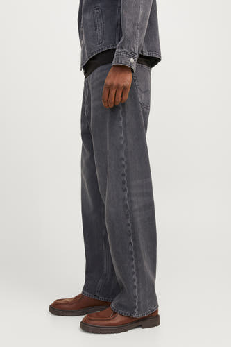 Jean décontracté de denim gris foncé de JACK & JONES JEANS INTELLIGENCE, vu de côté, avec des chaussures en cuir marron.