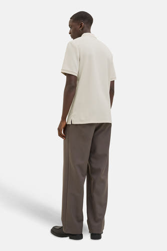 Beige polo met korte mouwen van CORE BY JACK & JONES, met een subtiele textuur, gecombineerd met bruine, wijde pantalon en zwarte schoenen.