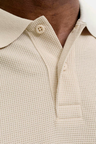 Beige polo met korte mouwen van CORE BY JACK & JONES, met wafelstructuur, crèmekleurige knopen en deels openstaande knoopsluiting.