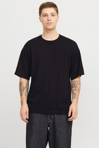 Zwart T-shirt met korte mouwen van PREMIUM by JACK & JONES, met tatoeages op beide armen, gecombineerd met een donkere jeans.
