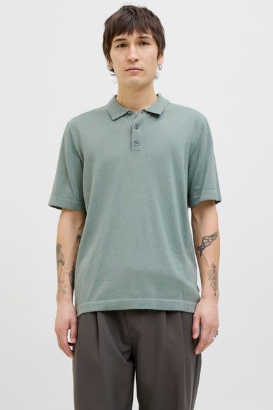 Groene polo met korte mouwen van PREMIUM by JACK & JONES, met knoopsluiting en gedragen met grijze pantalon.
