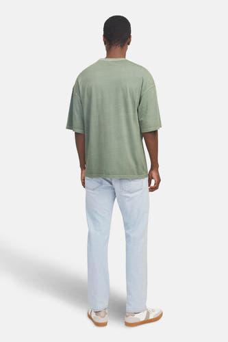 T-shirt vert de mantestes mants CORE Jack Jack & & & J, vuuuué avec des jeans bleus clairs et des baskets.