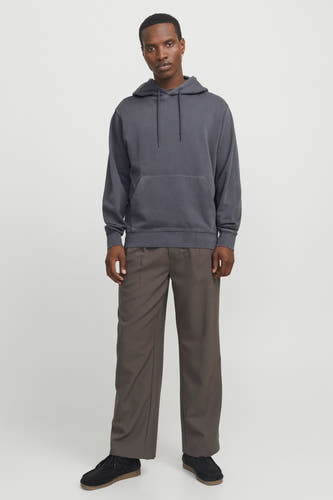 Grijze hoodie van CORE BY JACK & JONES met trekkoorden en kangoeroezak, gedragen door een model met bruine wijde broek en zwarte suède schoenen.