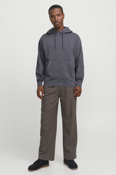 Grijze hoodie van CORE BY JACK & JONES met trekkoorden en kangoeroezak, gedragen door een model met bruine wijde broek en zwarte suède schoenen.