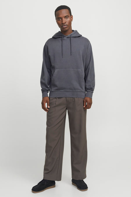 Sweat à capuche gris de CORE BY JACK & JONES avec cordons de serrage et poche kangourou, porté par un mannequin avec un pantalon ample marron et des chaussures en daim noires.