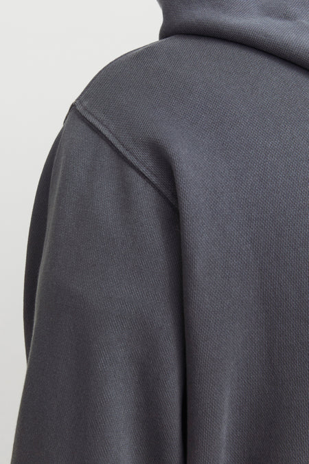 Grijze hoodie van CORE BY JACK & JONES met zichtbare ribtextuur en schoudernaad in close-up.