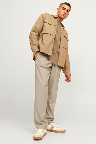 Ecru broek van JACK & JONES JEANS INTELLIGENCE, gecombineerd met een bruin shirt en witte sneakers.