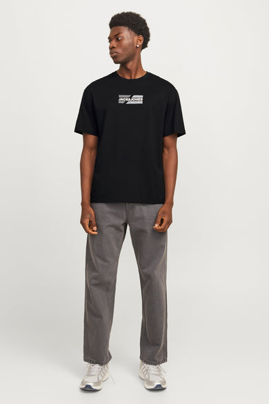 T-shirt noir à manches courtes de CORE par JACK & JONES, porté avec un pantalon gris et des baskets blanches.