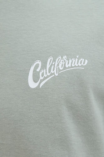 T-shirt vert de mantes manesmansSSSSS & J J J J avec " CaliforniaCalifornia" imprimé en blanc.