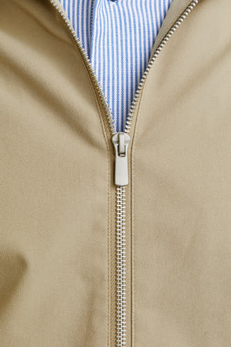Beige, manteau court d'ORIGINALS BY JACK & JONES, avec une fermeture éclair argentée et un chemisier rayé bleu et blanc en dessous.