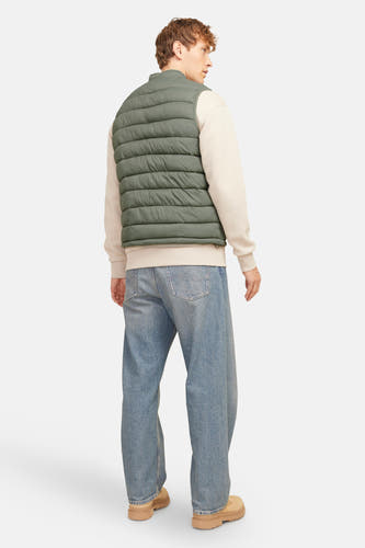 Kakikleurige bodywarmer van PREMIUM BLUE by JACK & JONES, met een gewatteerd ontwerp en gecombineerd met een crèmekleurige sweater en blauwe jeans.