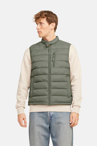 Kaki bodywarmer van PREMIUM BLUE by JACK & JONES, gedragen over een crèmekleurige sweater en blauwe jeans.
