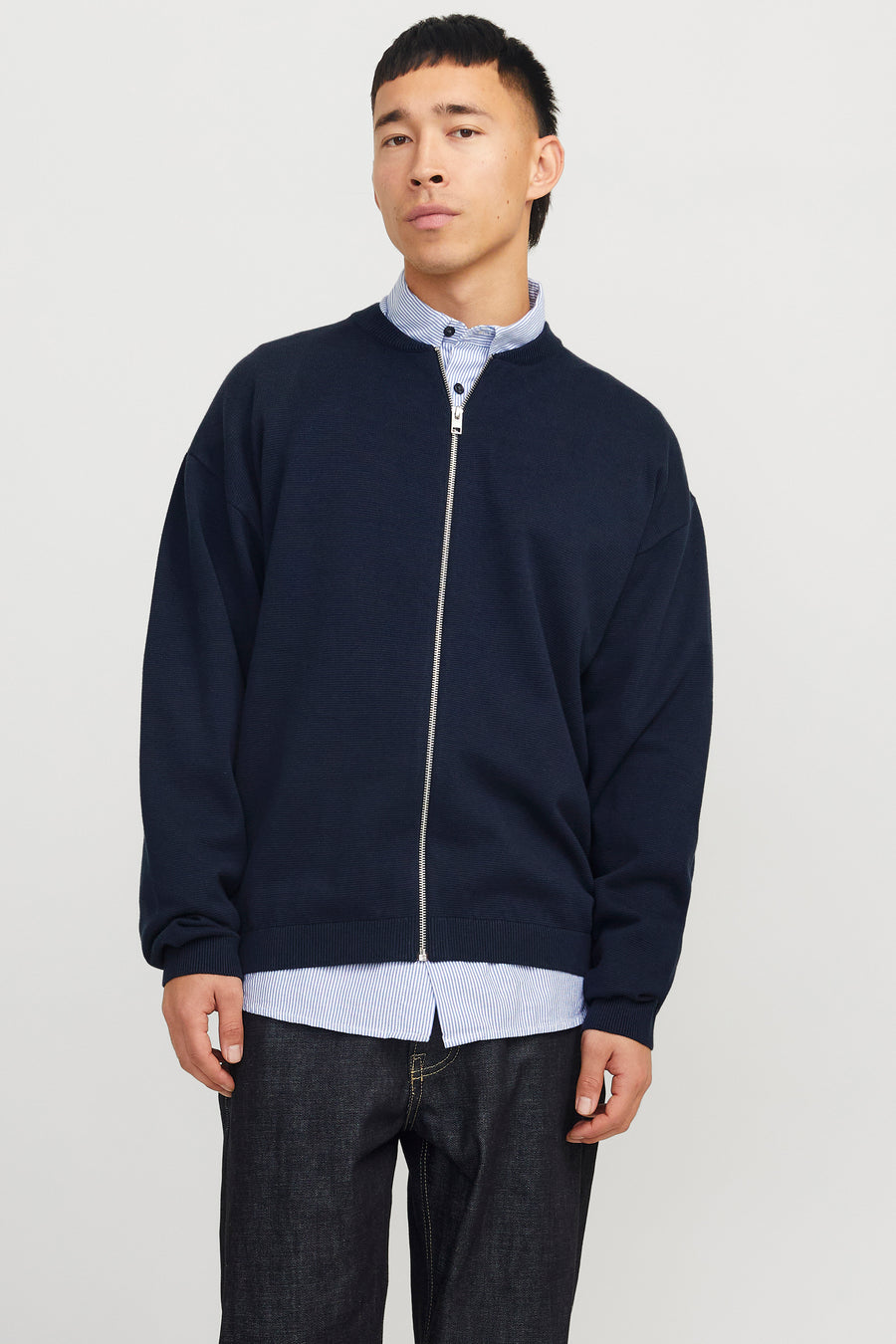 Blauw vest van ORIGINALS BY JACK & JONES, gedragen over een gestreept overhemd en donkere jeans.
