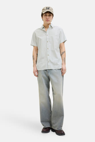 Groen gestreept overhemd met korte mouwen van PREMIUM BLUE by JACK & JONES, gedragen met een pet en wijde jeans.