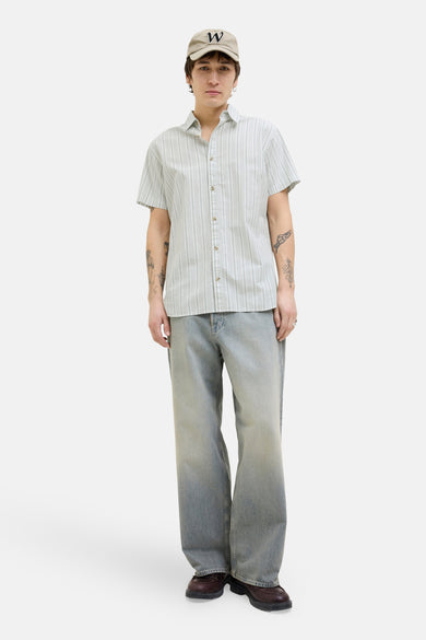 Groen gestreept overhemd met korte mouwen van PREMIUM BLUE by JACK & JONES, gedragen met een pet en wijde jeans.
