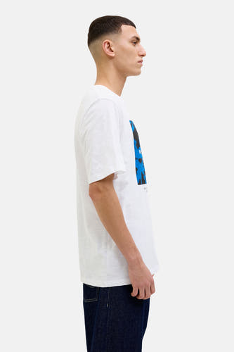 Wit T-shirt met korte mouwen van CORE BY JACK & JONES, zijaanzicht, met blauwe en zwarte print, gecombineerd met donkere jeans.