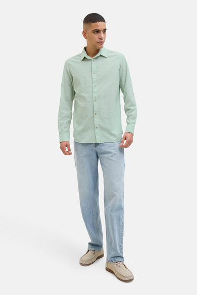 Groen overhemd met lange mouwen van PREMIUM by JACK & JONES, gedragen met lichtblauwe jeans en suède schoenen.