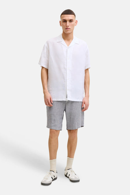 Grijze short van JACK & JONES JEANS INTELLIGENCE met fijne textuur, gestyled met een wit overhemd en sportschoenen.