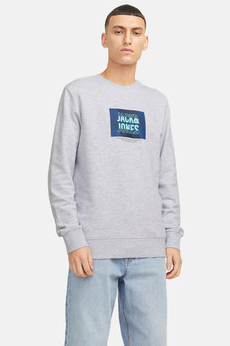 Pull-over gris de CORE par JACK & JONES, avec logo sur la poitrine et associé à des jeans.