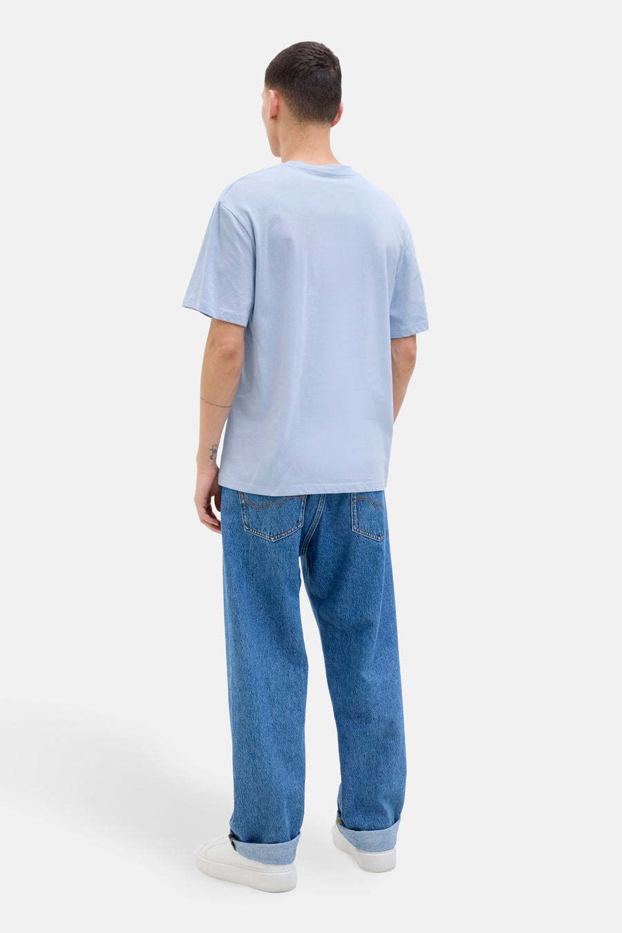 T-shirt bleu à manches courtes d'ORIGINALS BY JACK & JONES, dos, porté avec des jeans décontractés et des baskets blanches.