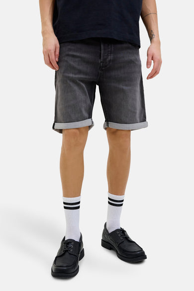 Shorts en denim noir de JACK & JONES JEANS INTELLIGENCE, avec des poches rabattues et des chaussettes blanches à rayures noires.