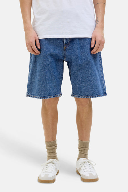 Mid-blauwe denim short van JACK & JONES JEANS INTELLIGENCE met losse pasvorm, gedragen met een wit T-shirt, beige sokken en witte sneakers.