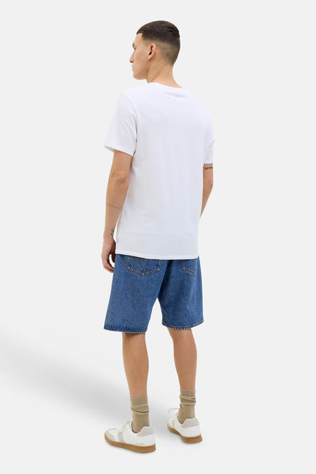 Mid-blauwe jeansshort van JACK & JONES JEANS INTELLIGENCE, achteraanzicht van een man met een wit T-shirt, beige sokken en sneakers.